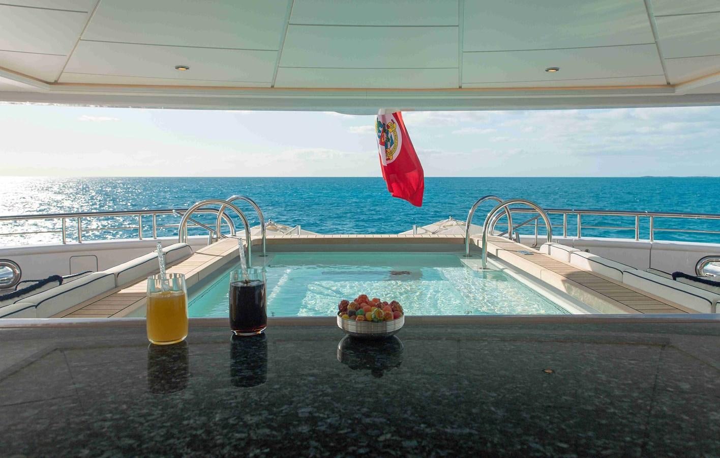 a flag on a railing over a body of water aboard AURORA Yacht for Sale