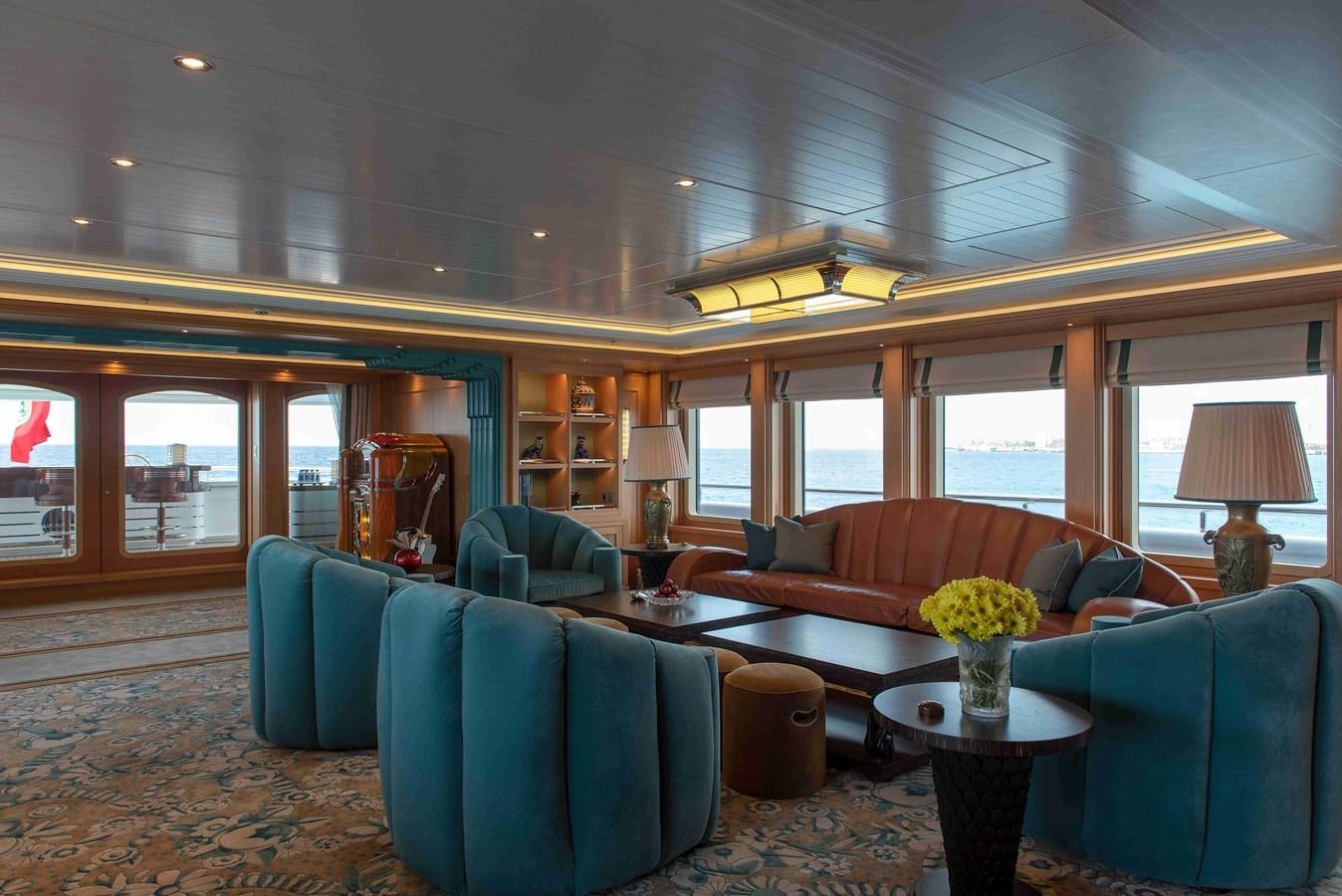 a living room with blue couches aboard AURORA Yacht for Sale
