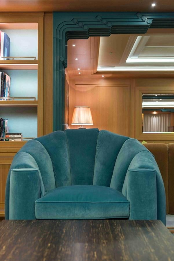 a blue couch in a room aboard AURORA Yacht for Sale