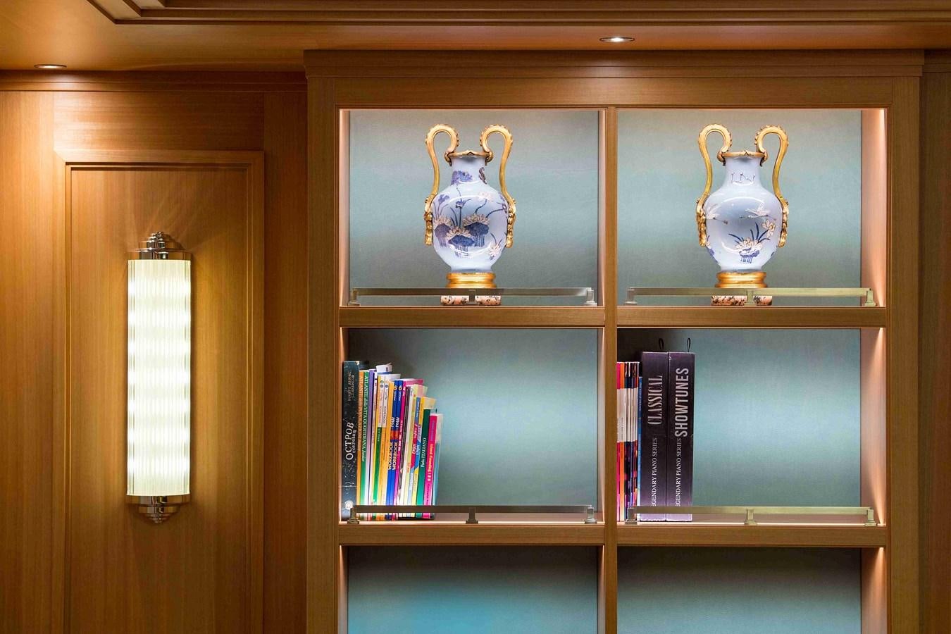 a bookshelf with a vase and a cup on top aboard AURORA Yacht for Sale