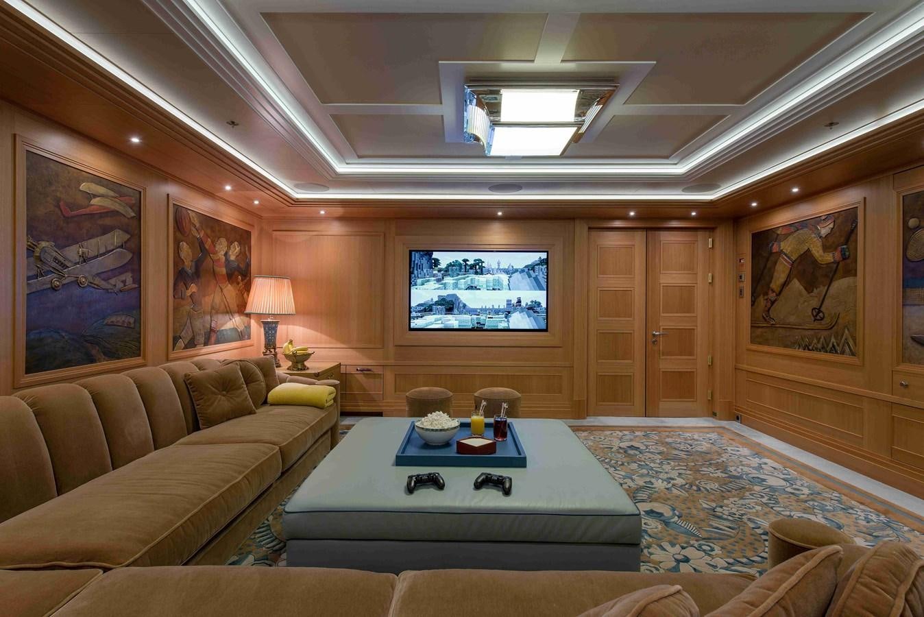 a living room with a large blue table and a large window aboard AURORA Yacht for Sale