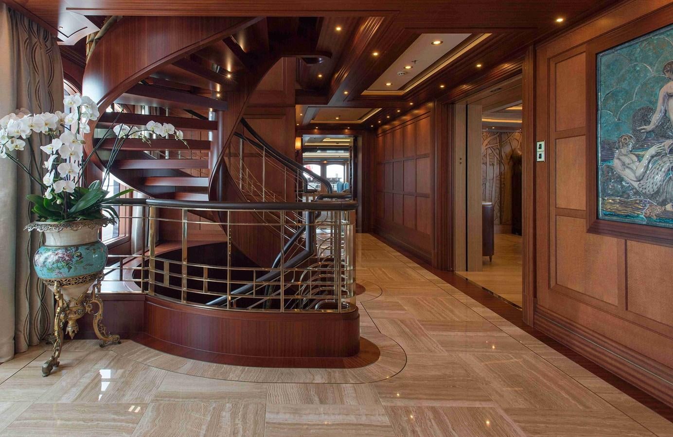 a large room with a staircase and flowers aboard AURORA Yacht for Sale