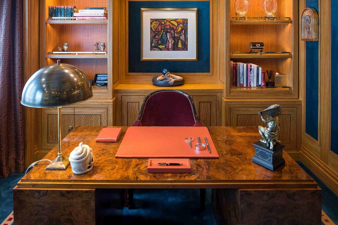 a table with a lamp and a book on it aboard AURORA Yacht for Sale