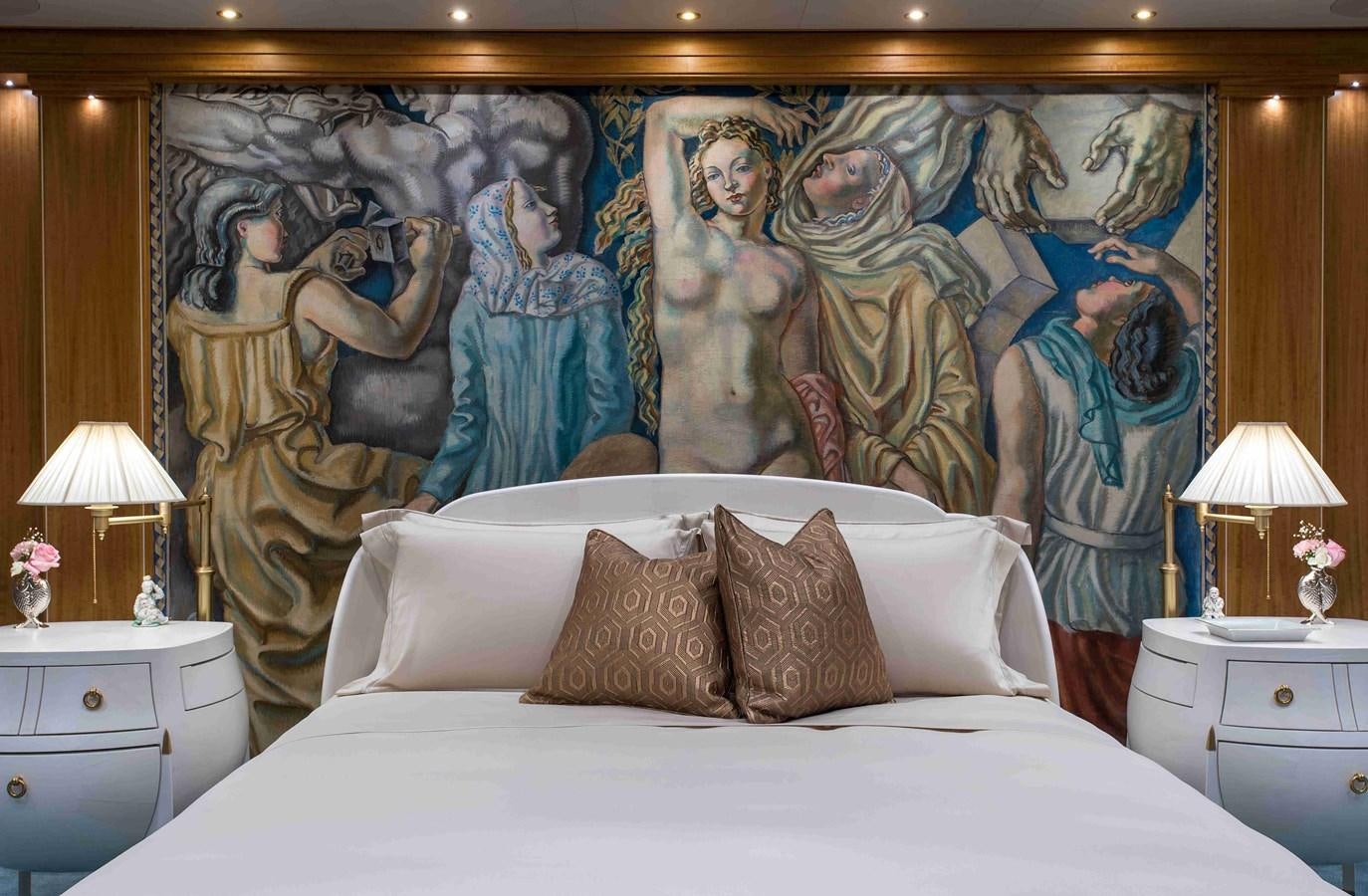 a bed with a painting on the wall aboard AURORA Yacht for Sale