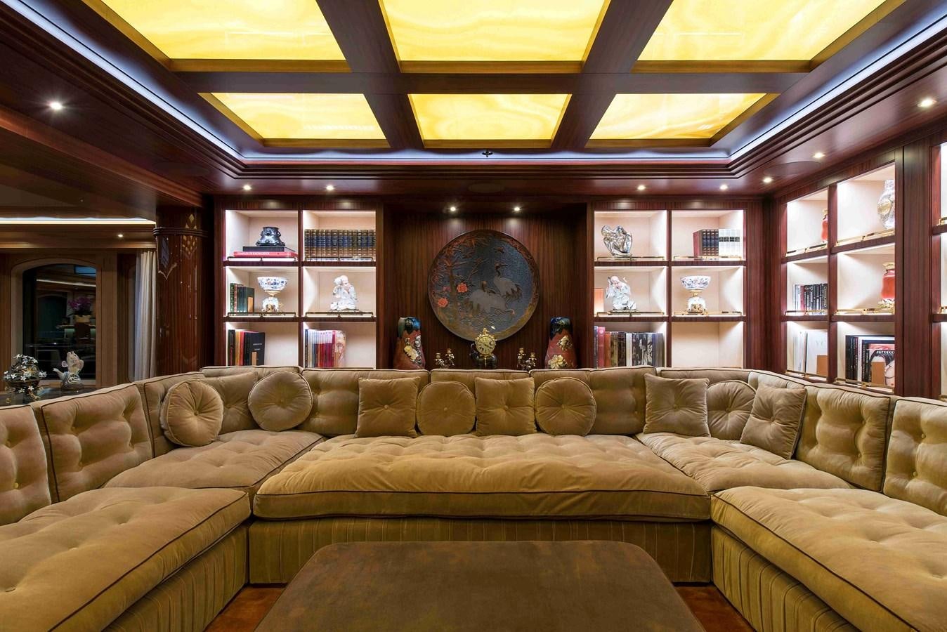 a large living room with a large clock on the wall aboard AURORA Yacht for Sale