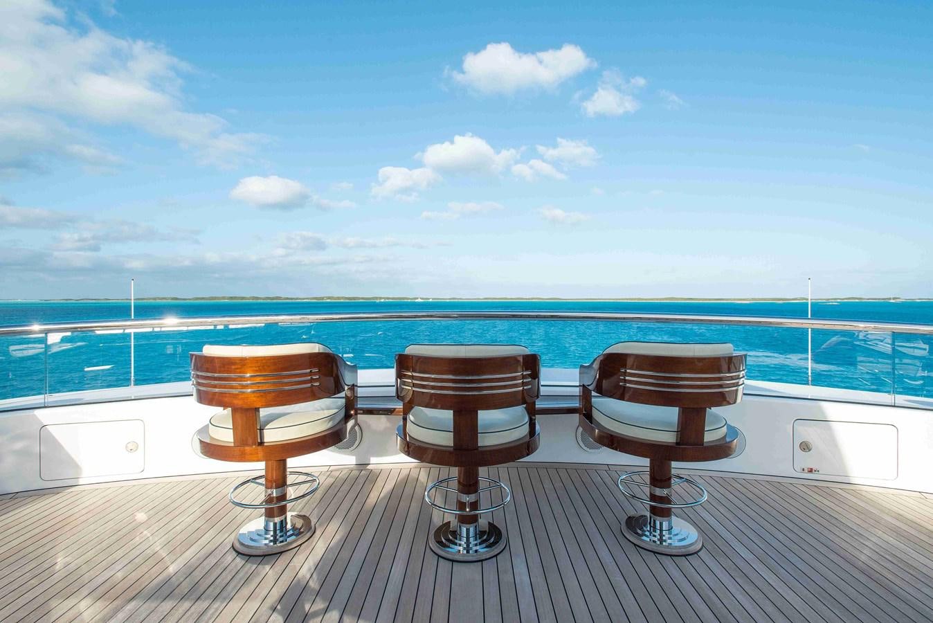 a group of brown chairs on a deck overlooking a body of water aboard AURORA Yacht for Sale