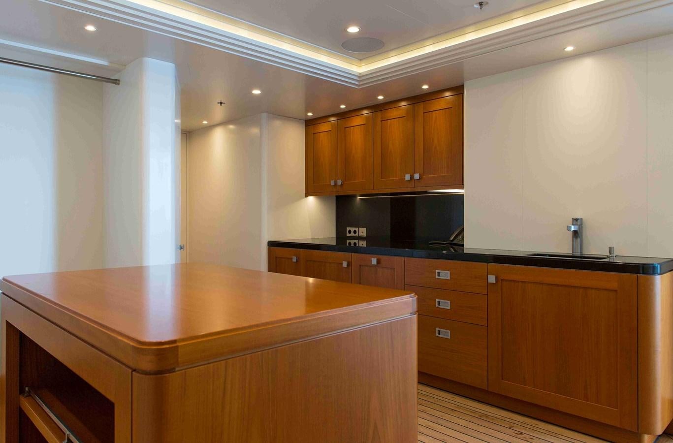 a kitchen with wooden cabinets aboard AURORA Yacht for Sale