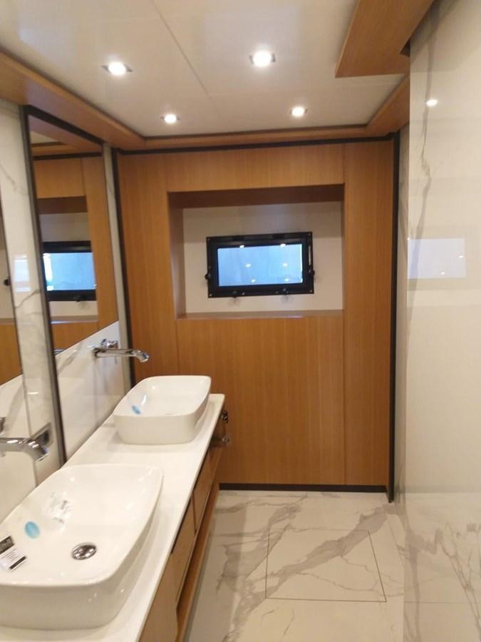 a bathroom with a sink and a tv on the wall aboard BLUEY Yacht for Sale