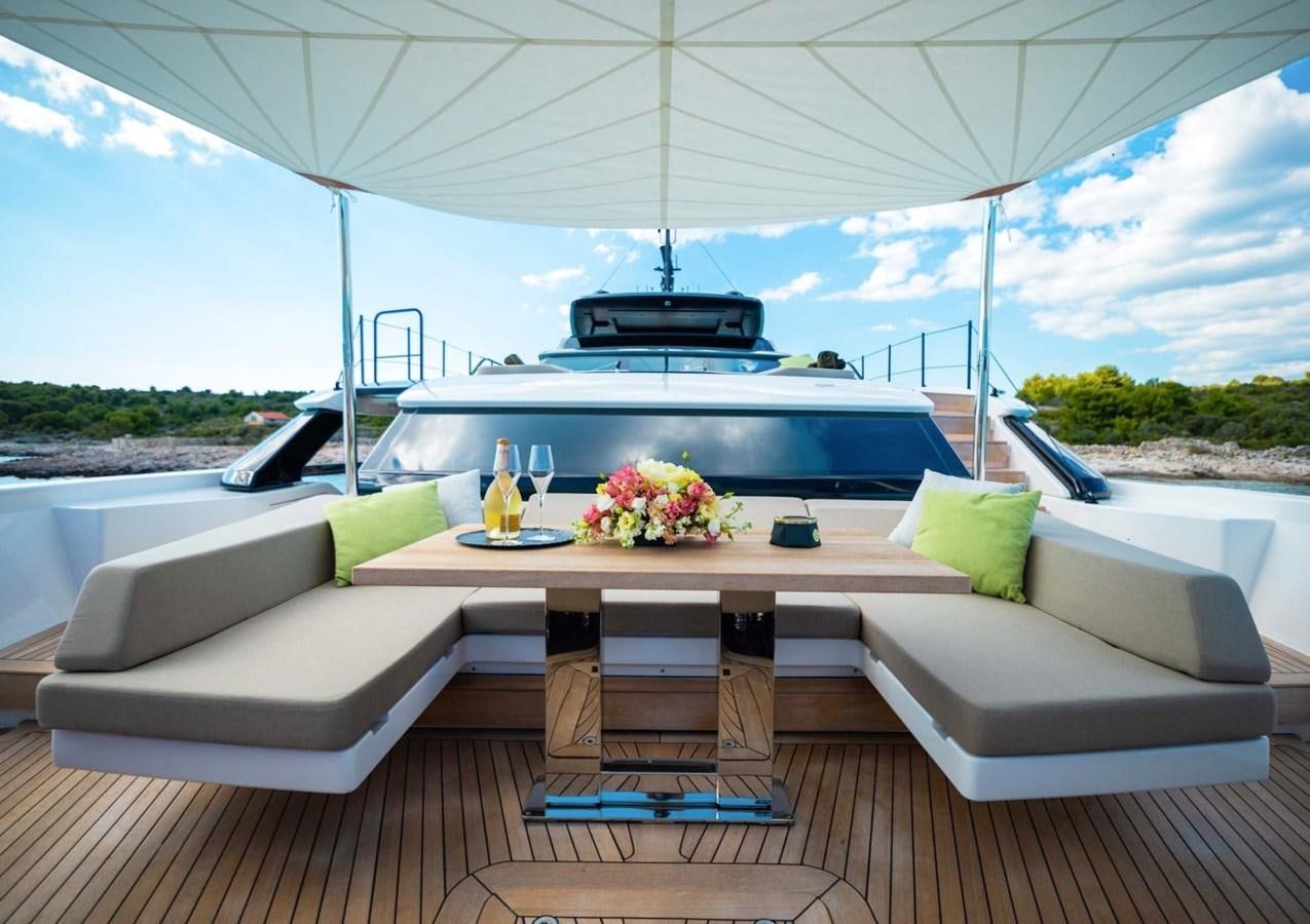 a white couch with a table and chairs on it aboard ASYMMETRIC Yacht for Sale
