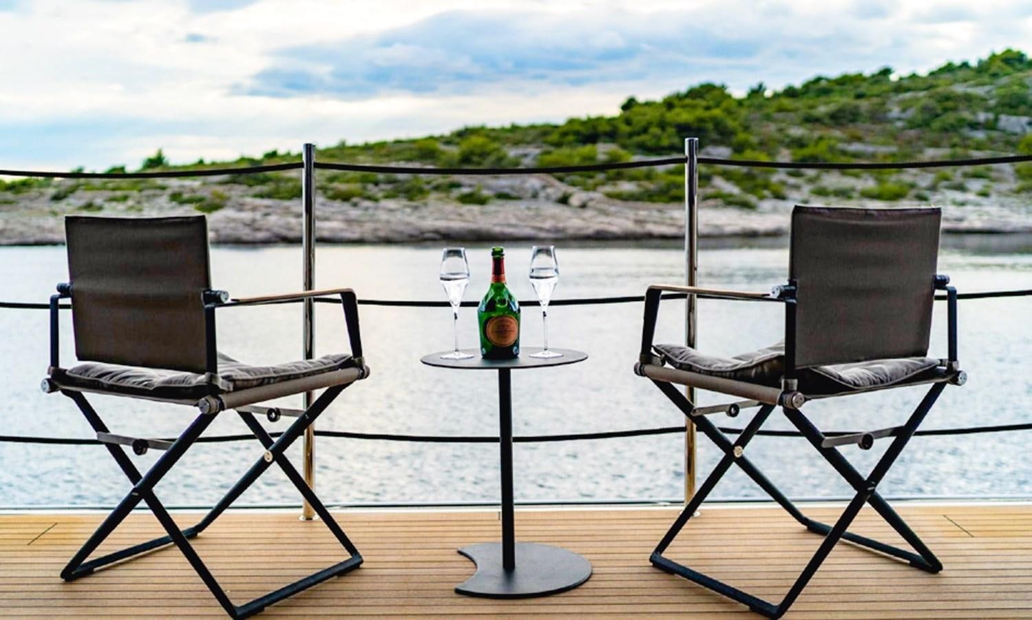 a table and chairs on a deck aboard ASYMMETRIC Yacht for Sale