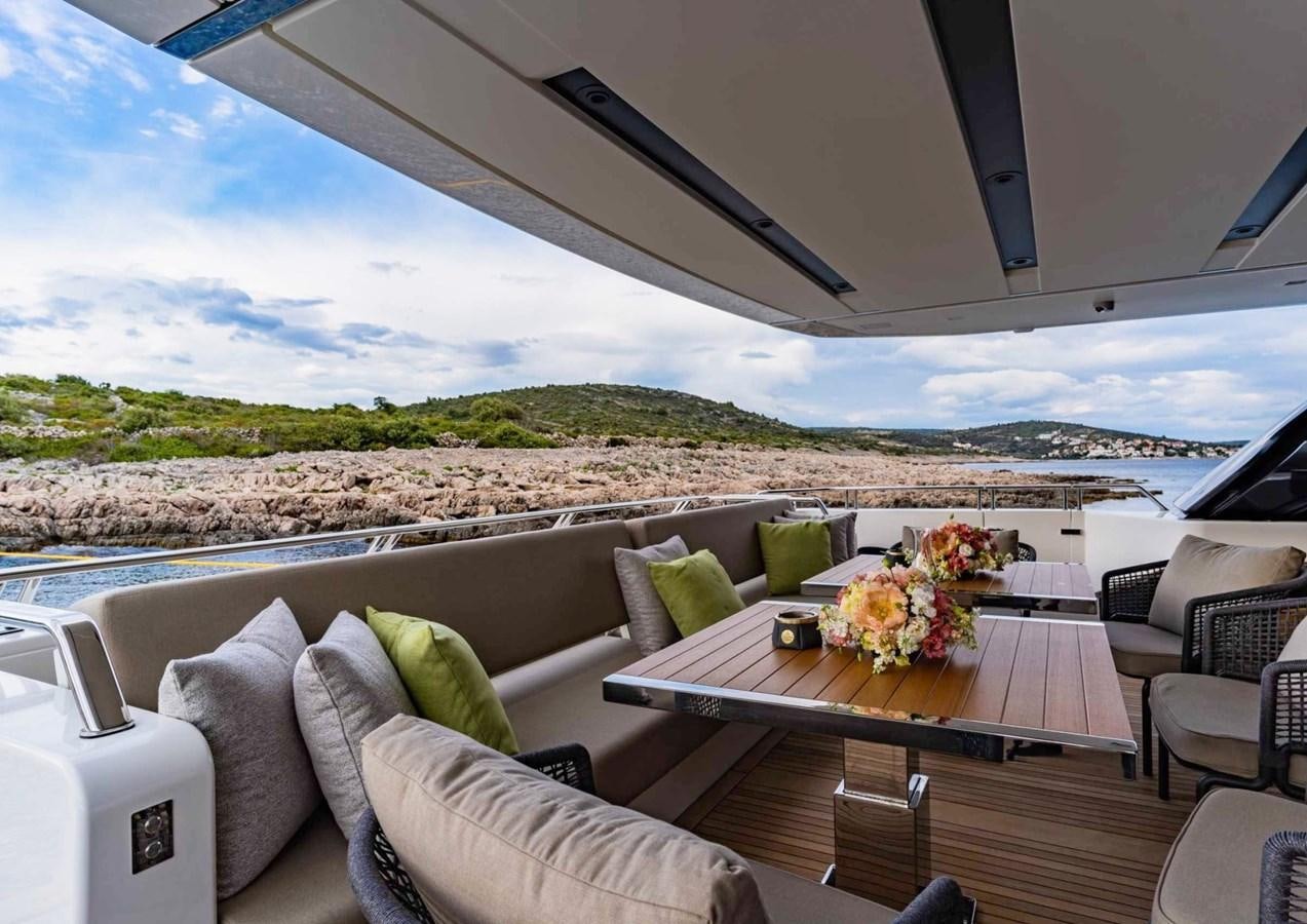 a table with chairs and a view of the mountains aboard ASYMMETRIC Yacht for Sale