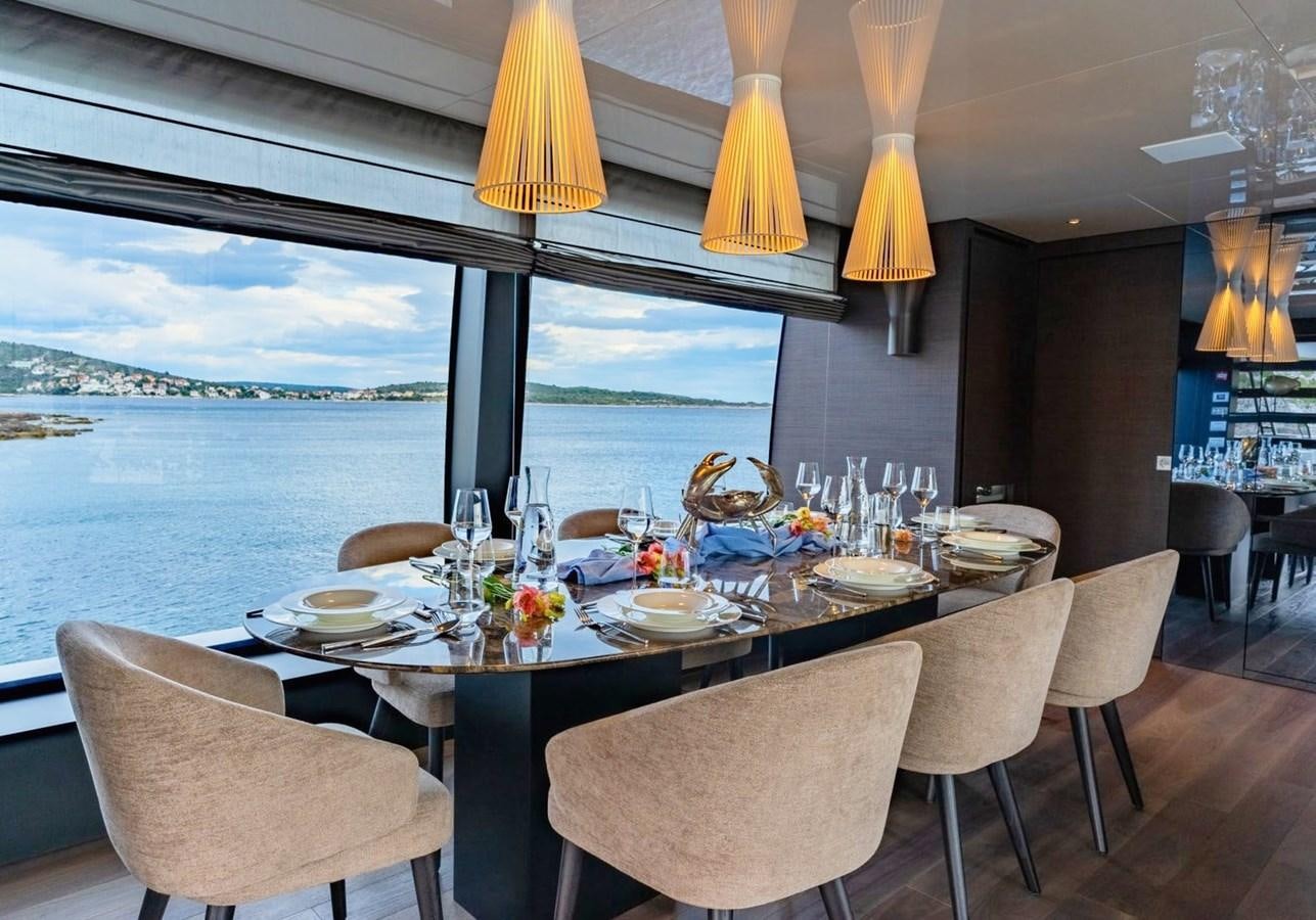 a dining table with a view of the ocean aboard ASYMMETRIC Yacht for Sale