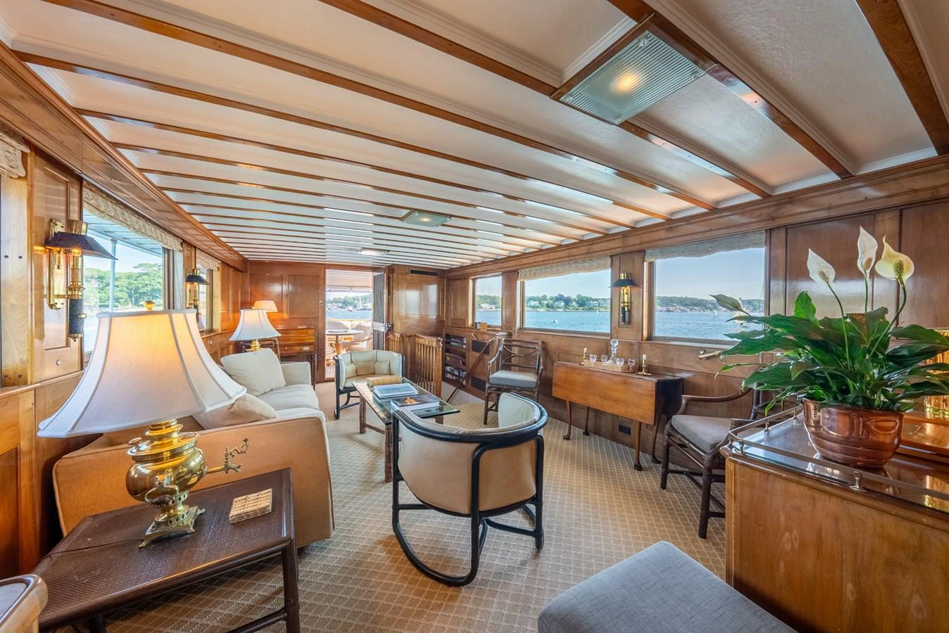 a room with a table chairs and a plant in it aboard BERNADETTE Yacht for Sale