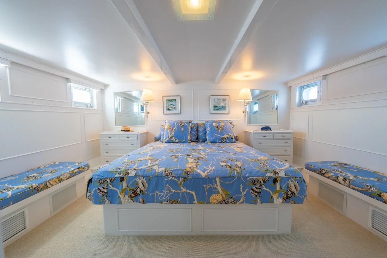 a bedroom with a bed and a blue bed spread aboard BERNADETTE Yacht for Sale