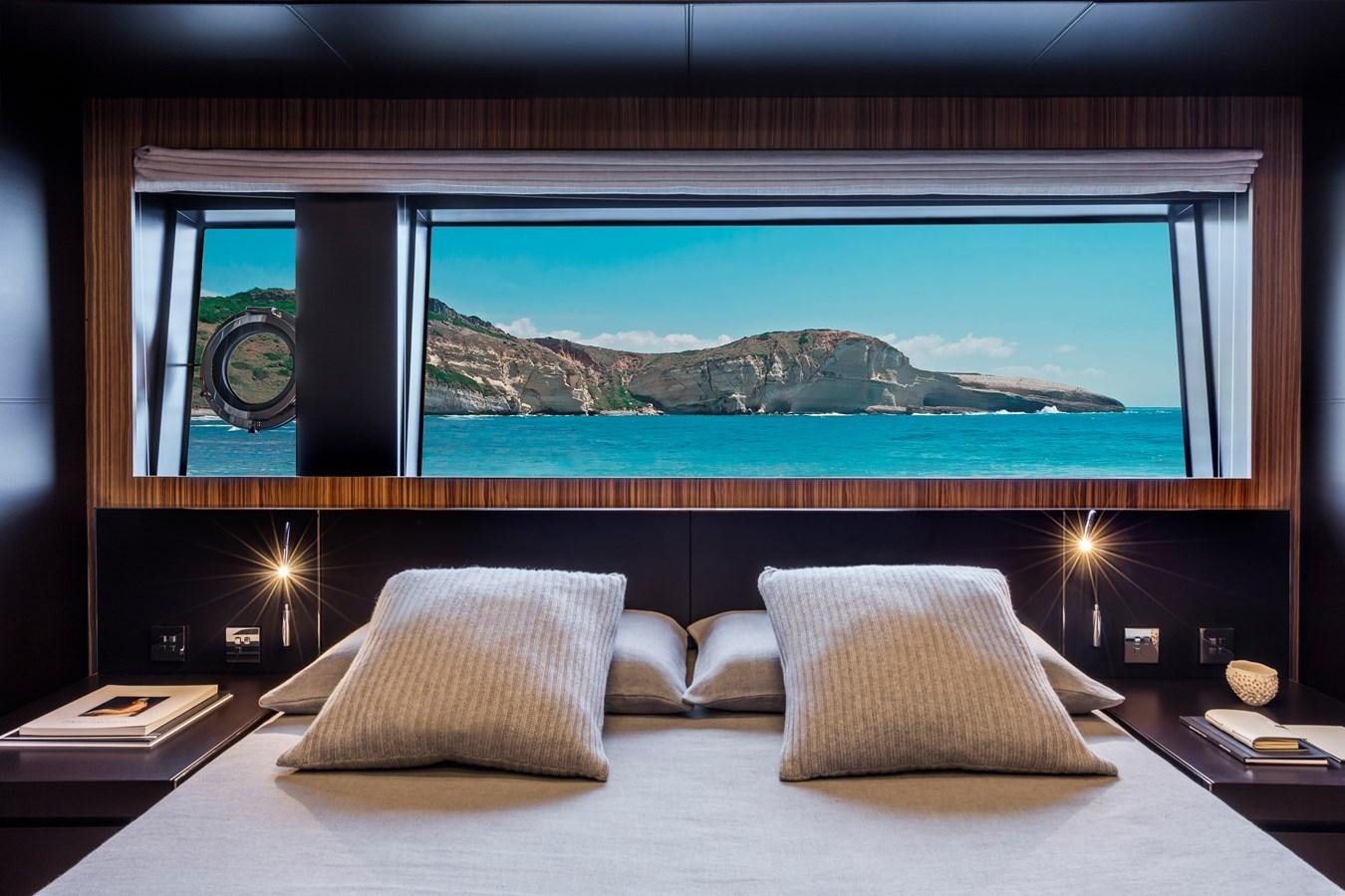 a bed with pillows and a painting on the wall aboard IRON GRYPHON Yacht for Sale