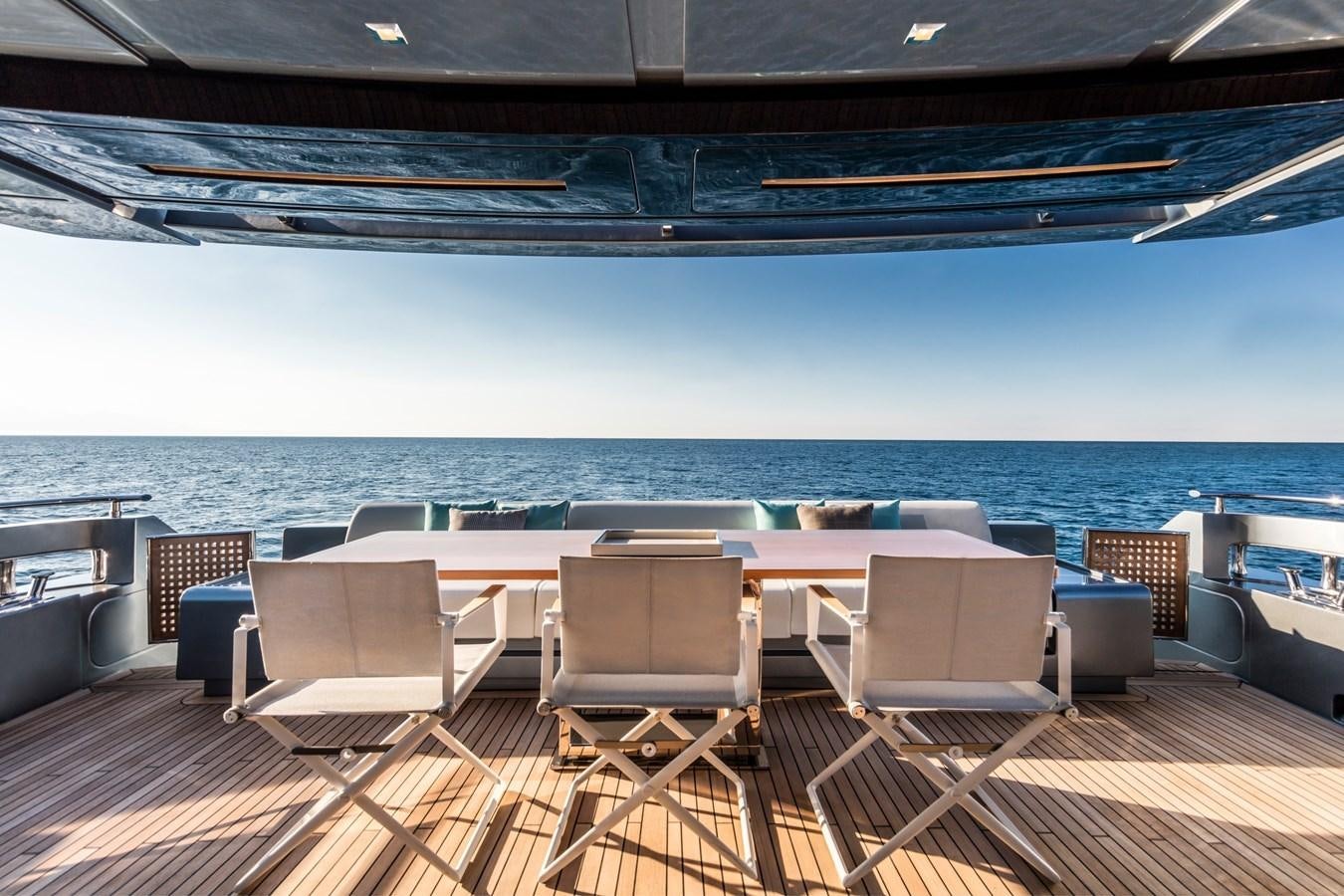 a deck with chairs and a large body of water in the background aboard IRON GRYPHON Yacht for Sale