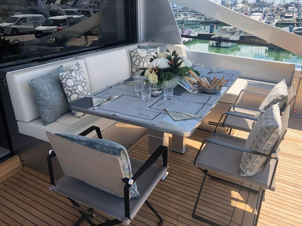 a table with chairs and a couch aboard QUEEN B SPORT Yacht for Sale