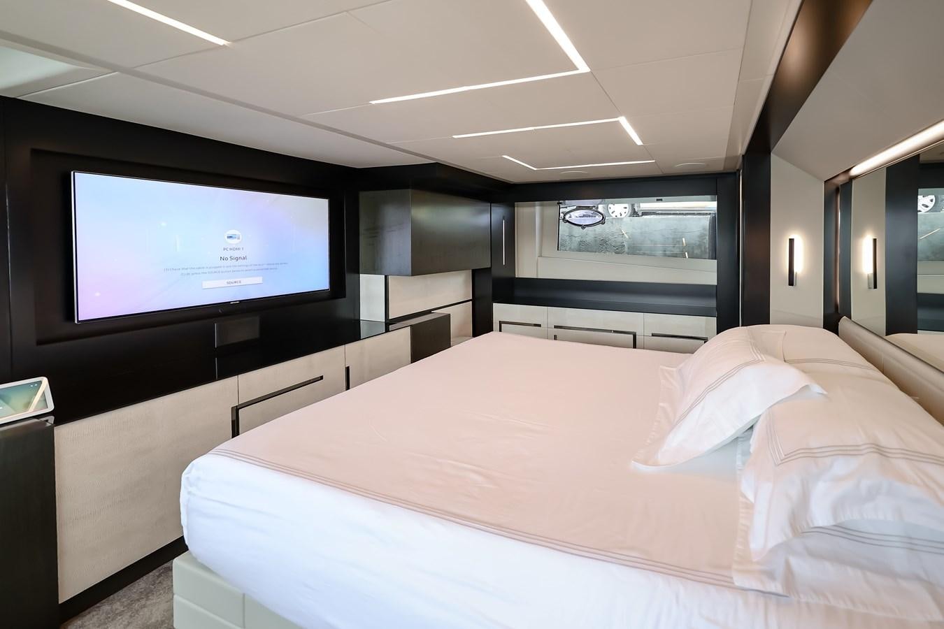 a room with a bed and a tv on the wall aboard QUEEN B SPORT Yacht for Sale
