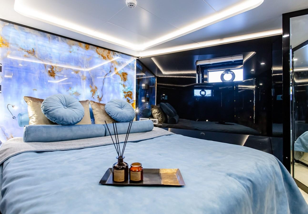 a bed with a blue blanket aboard BERING 70 LEVANNA Yacht for Sale