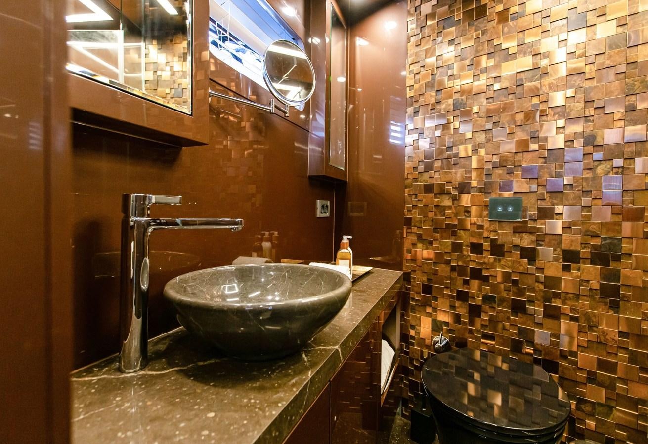 a bathroom with a sink and a tiled wall aboard BERING 70 LEVANNA Yacht for Sale