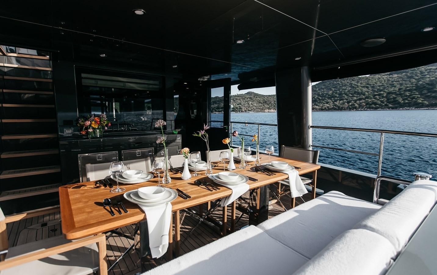 a dining table in a room with a view of the ocean aboard BERING 70 LEVANNA Yacht for Sale