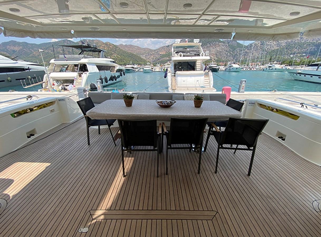 a table and chairs on a deck aboard BMO Yacht for Sale