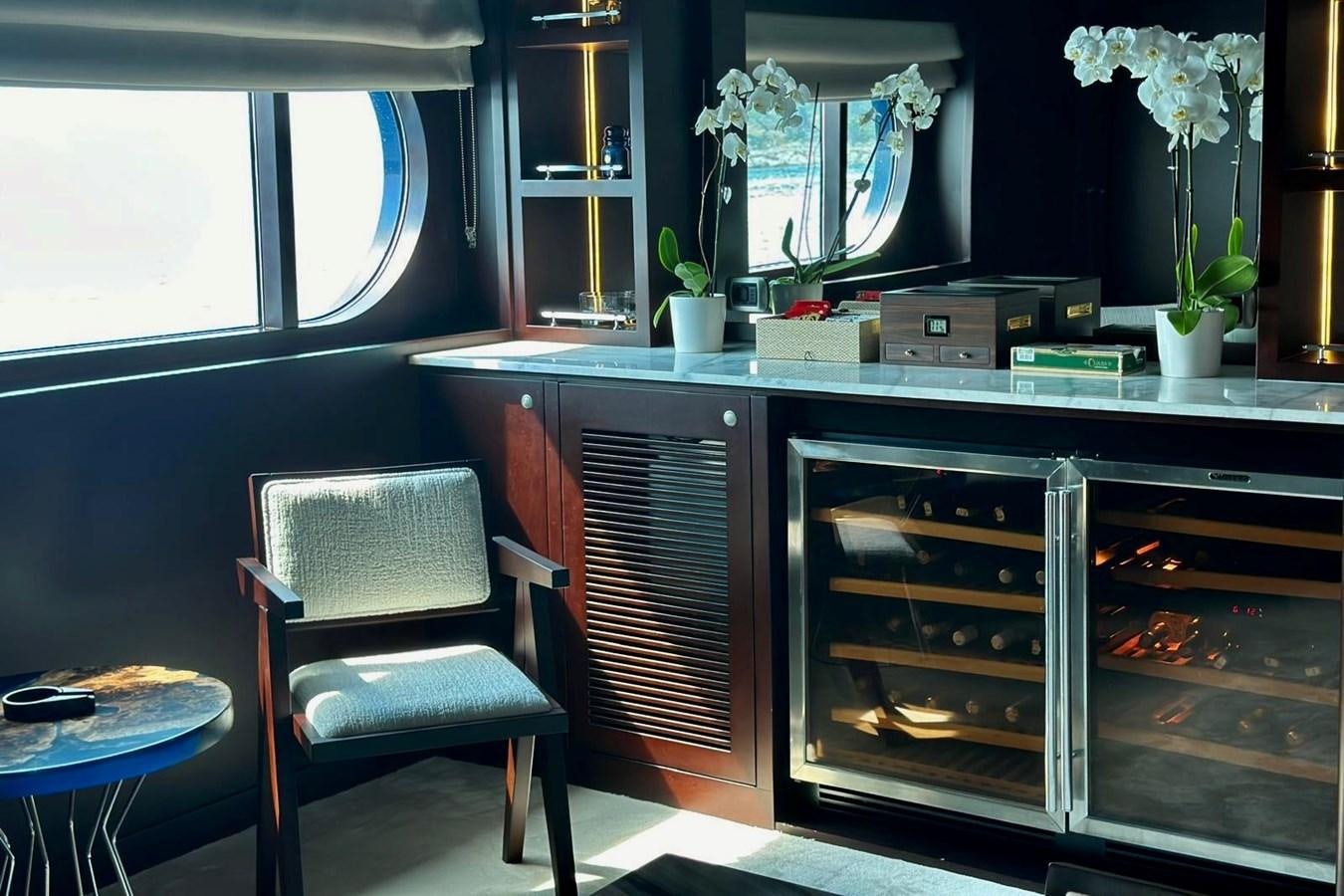 a kitchen with a stove and chairs aboard KORU Yacht for Sale