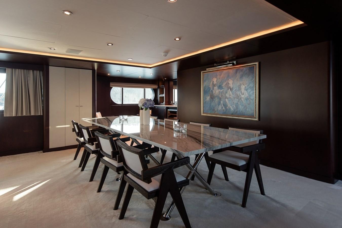 a dining room with a table and chairs aboard KORU Yacht for Sale