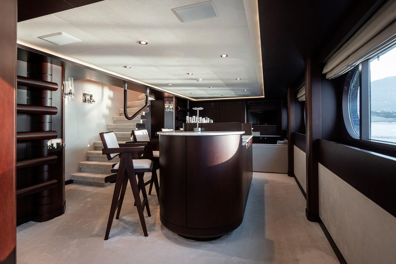 a room with a large black tub and wooden stairs aboard KORU Yacht for Sale