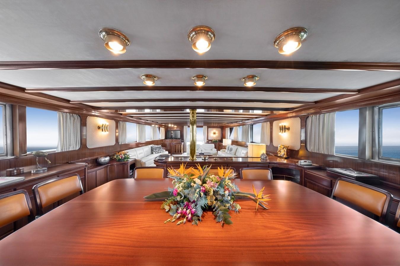 a large room with a wood table and chairs aboard ATHINA Yacht for Sale