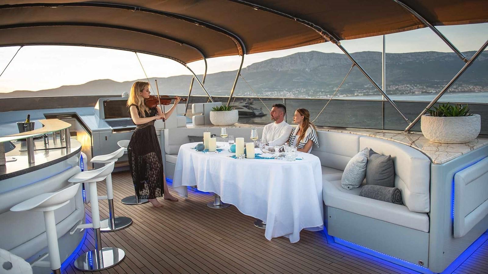 a group of people sitting around a table aboard ANAVI Yacht for Sale