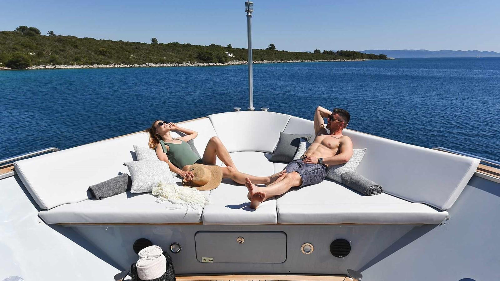 a man and woman in a white boat on the water aboard ANAVI Yacht for Sale
