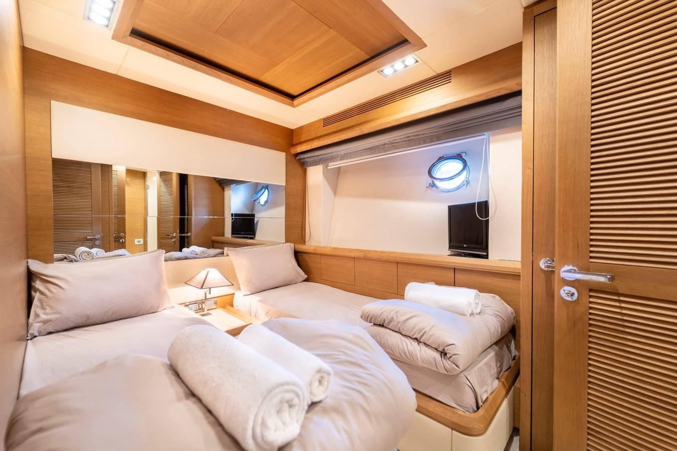 a room with a bed and a television aboard LEONARDO Yacht for Sale