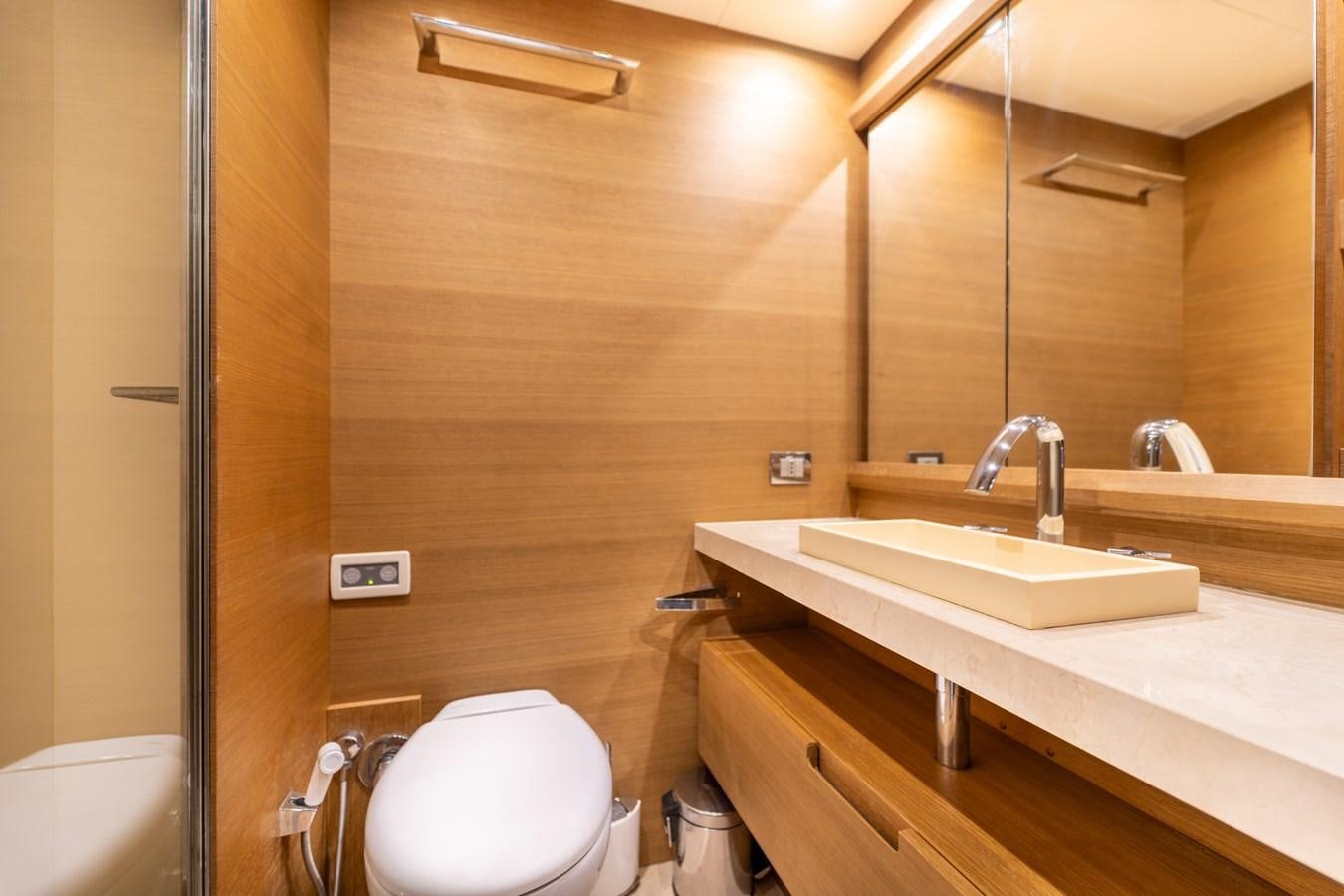 a bathroom with a sink toilet and a mirror aboard LEONARDO Yacht for Sale