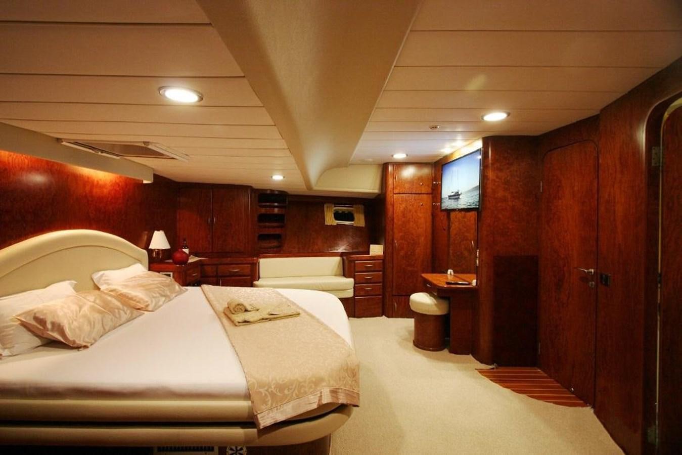 a room with a bed and a wood cabinet aboard EUPH Yacht for Sale