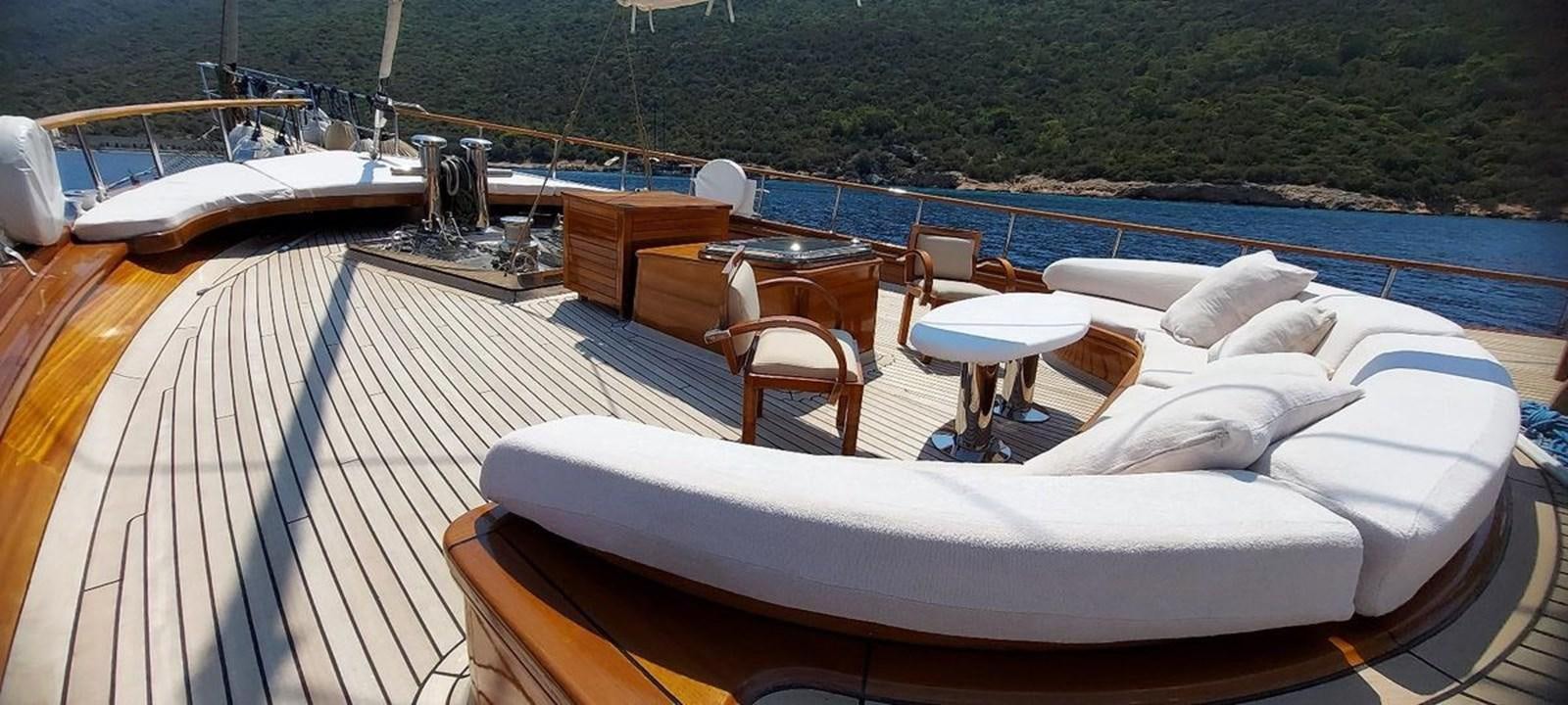 a deck with a large boat and chairs on it aboard SYY Yacht for Sale