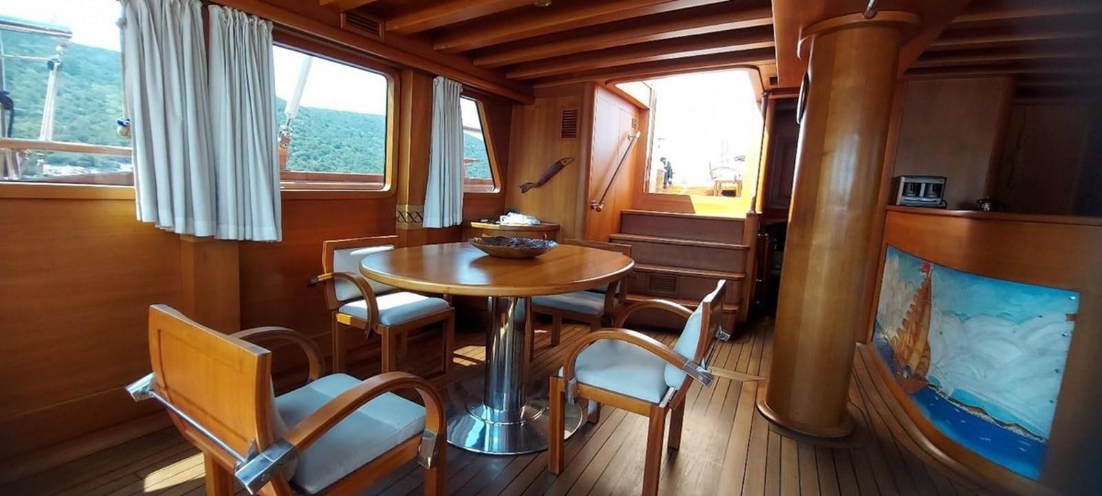 a room with a table and chairs aboard SYY Yacht for Sale
