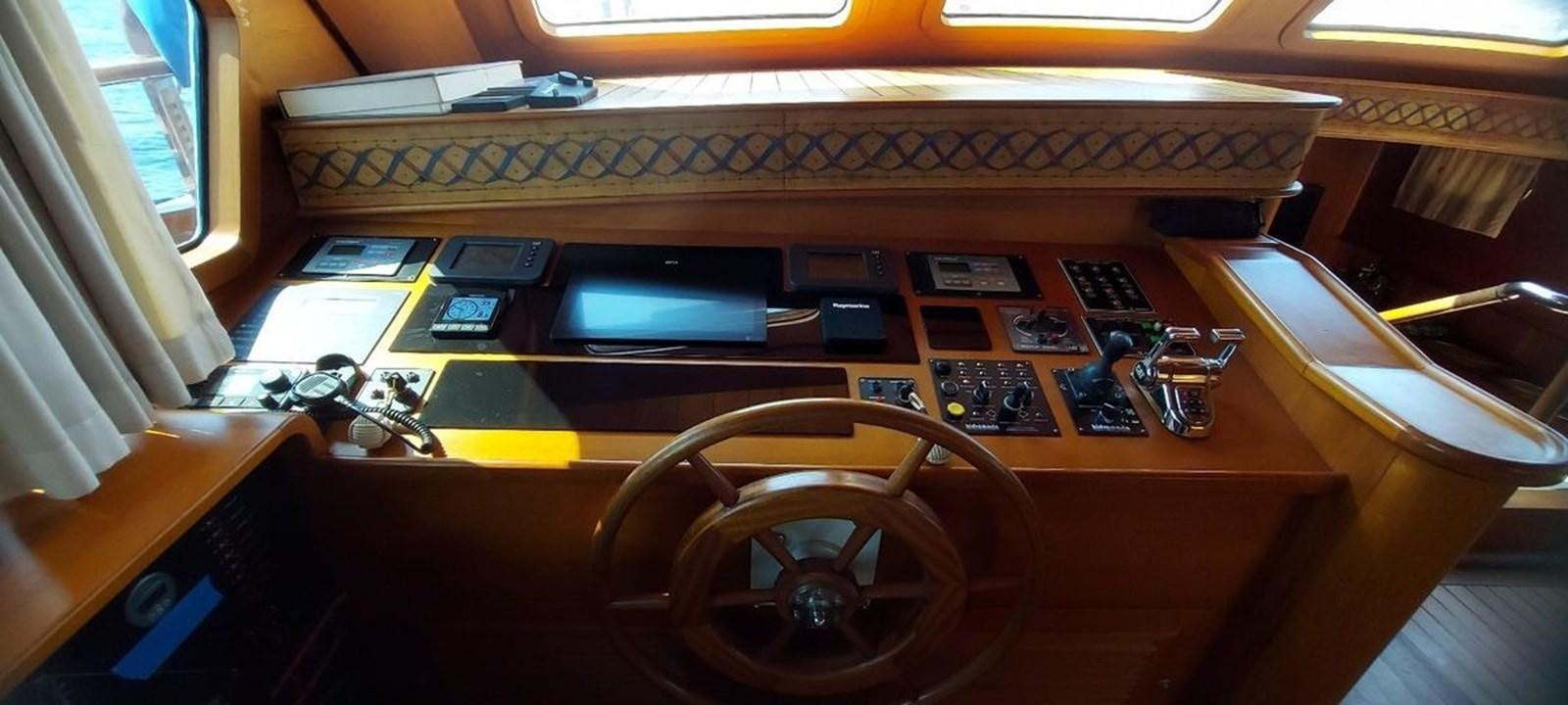 a wooden desk with a computer and other electronics on it aboard SYY Yacht for Sale