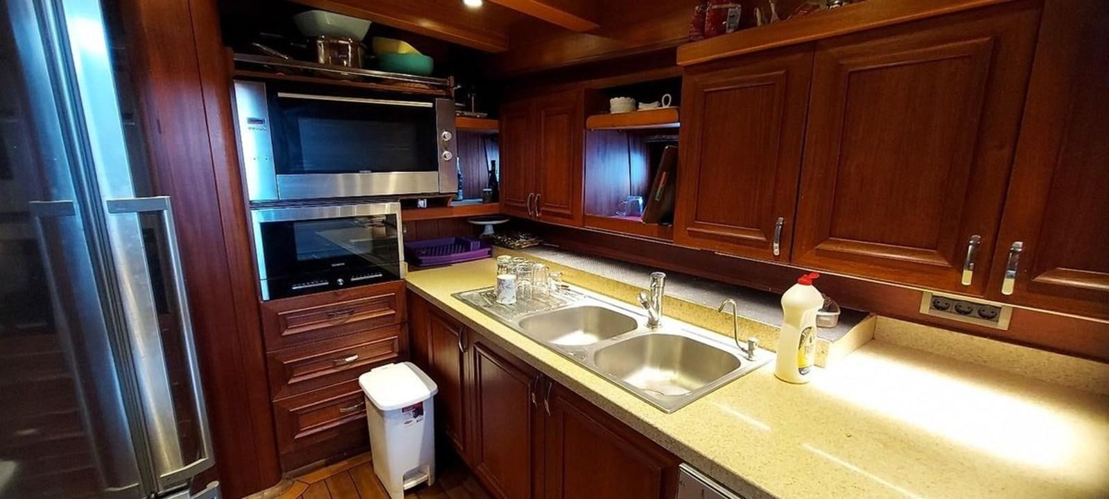 a kitchen with wooden cabinets aboard SYY Yacht for Sale