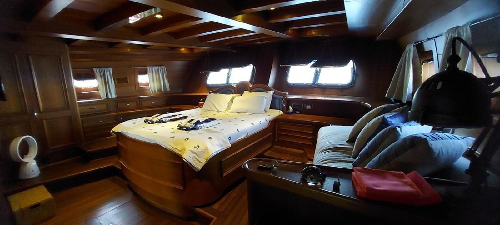 a bedroom with a bed and a couch aboard SYY Yacht for Sale