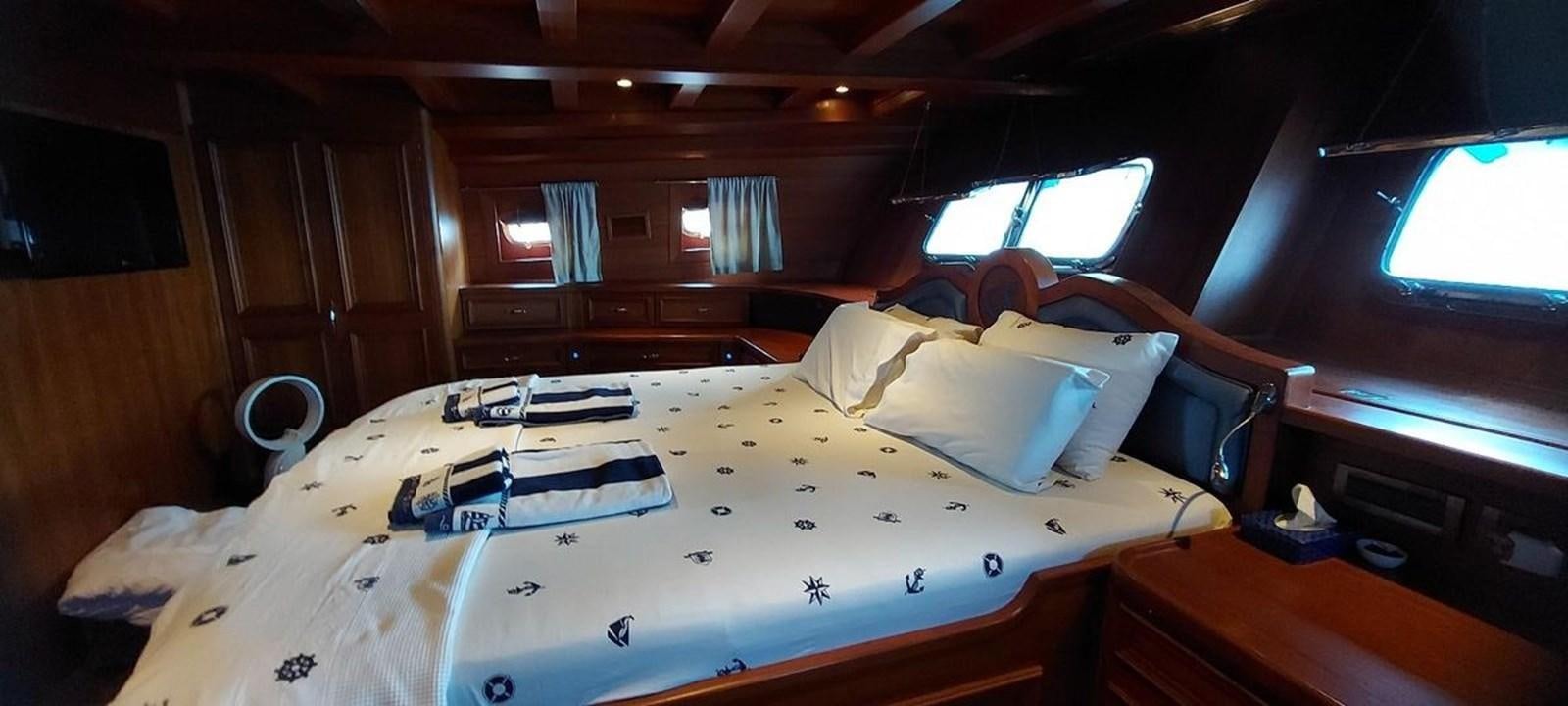 a bed with a white sheet and a blue sheet on it aboard SYY Yacht for Sale