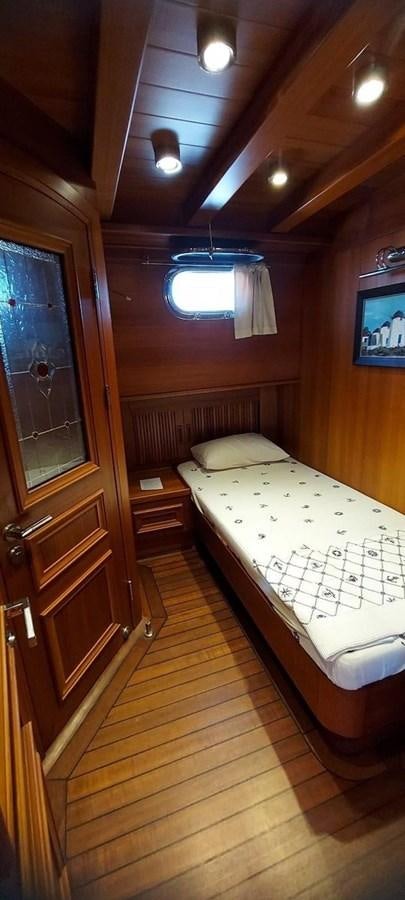 a bedroom with a bed and a window aboard SYY Yacht for Sale