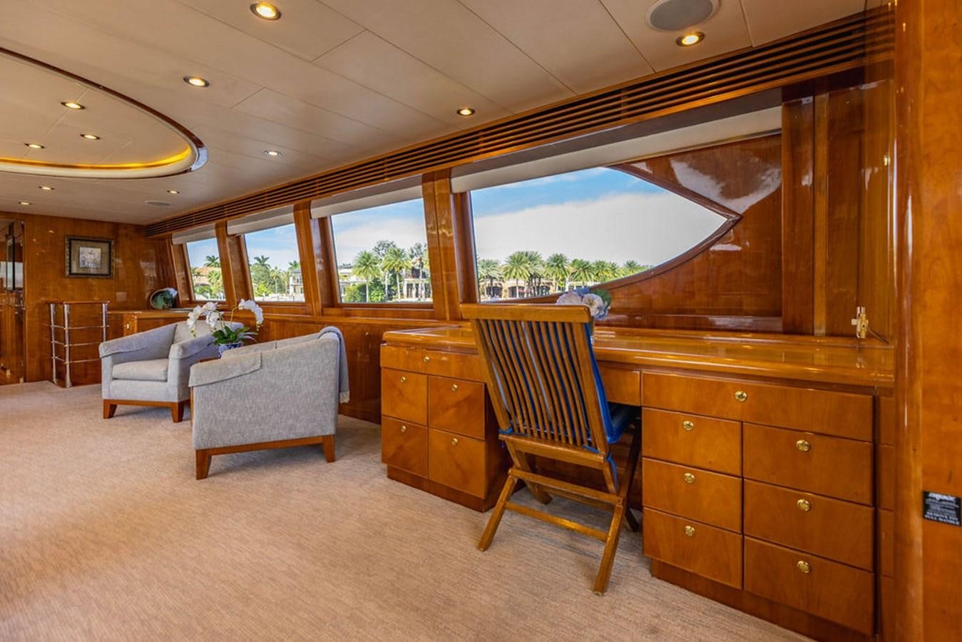 a room with a wood cabinet and a chair and a large window aboard NO REGRETS Yacht for Sale