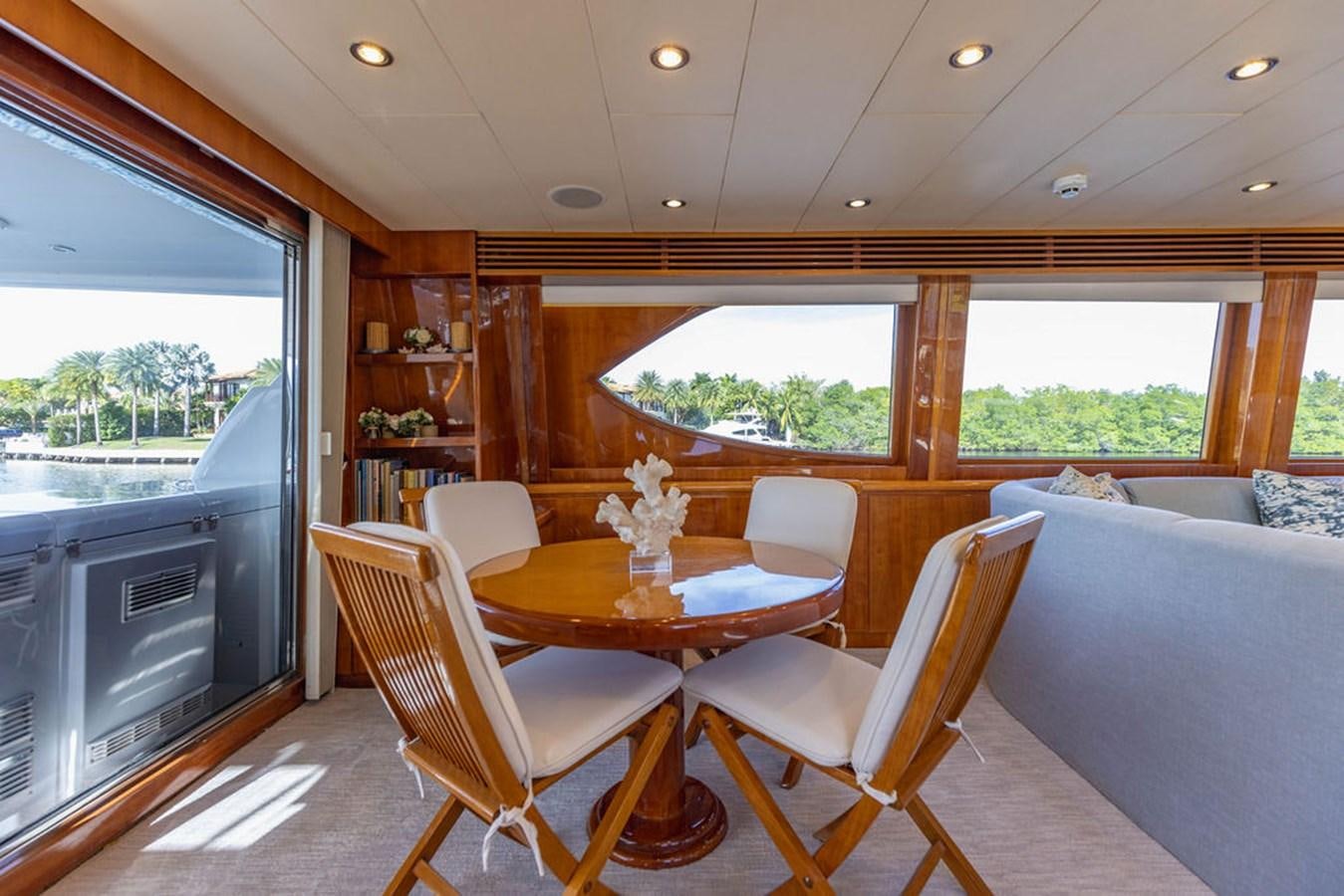 a dining table and chairs in a room with a window aboard NO REGRETS Yacht for Sale