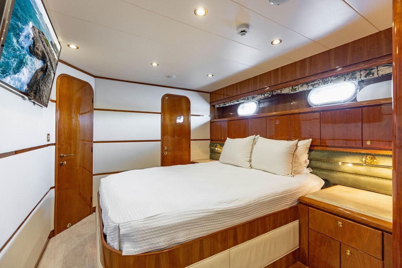 a room with a bed and a wood cabinet aboard NO REGRETS Yacht for Sale