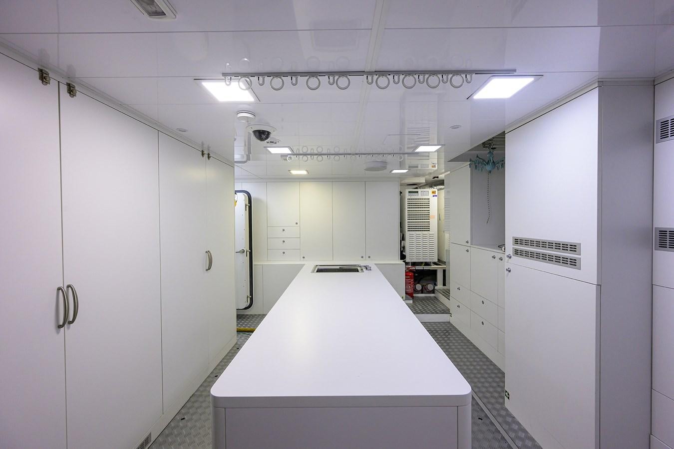 a long white counter with a few doors and a white wall aboard UPTIGHT Yacht for Sale