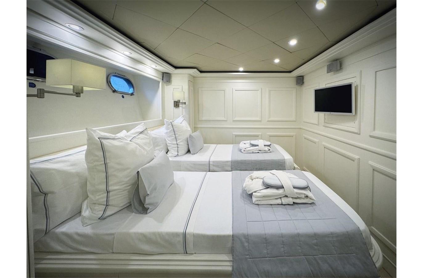 a white bed with white sheets aboard ZIACANAIA Yacht for Sale