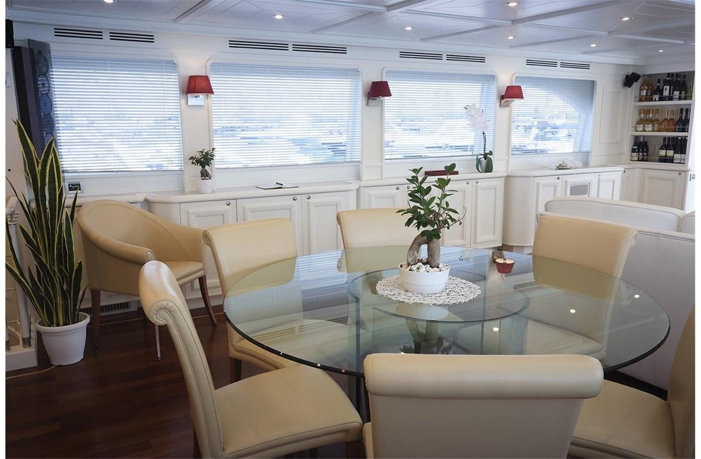 a room with a table chairs and plants aboard ZIACANAIA Yacht for Sale