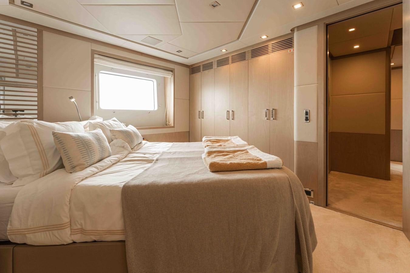 a bedroom with a bed and a window aboard COCONUTS Yacht for Sale