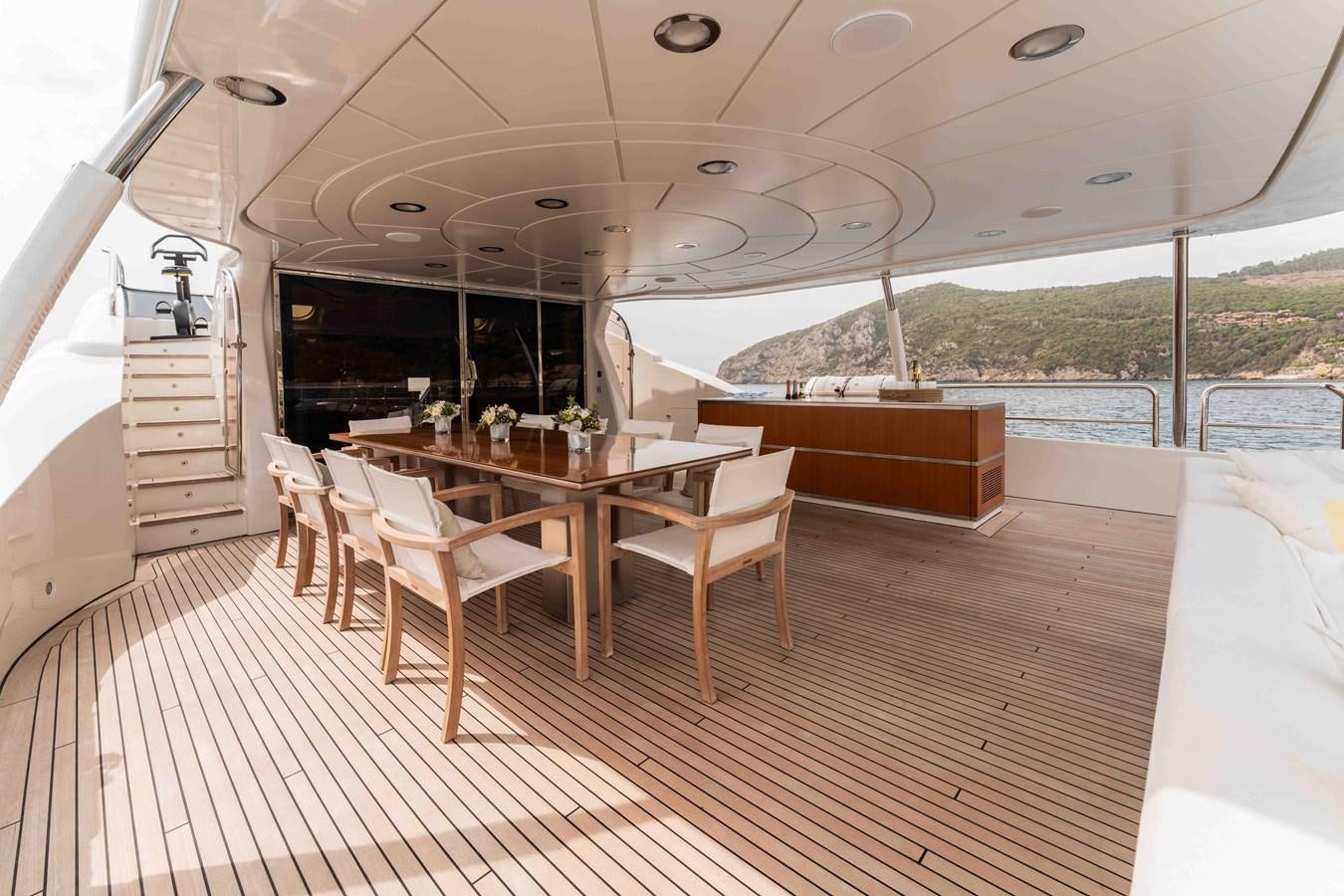 a wooden table and chairs on a boat aboard COCONUTS Yacht for Sale